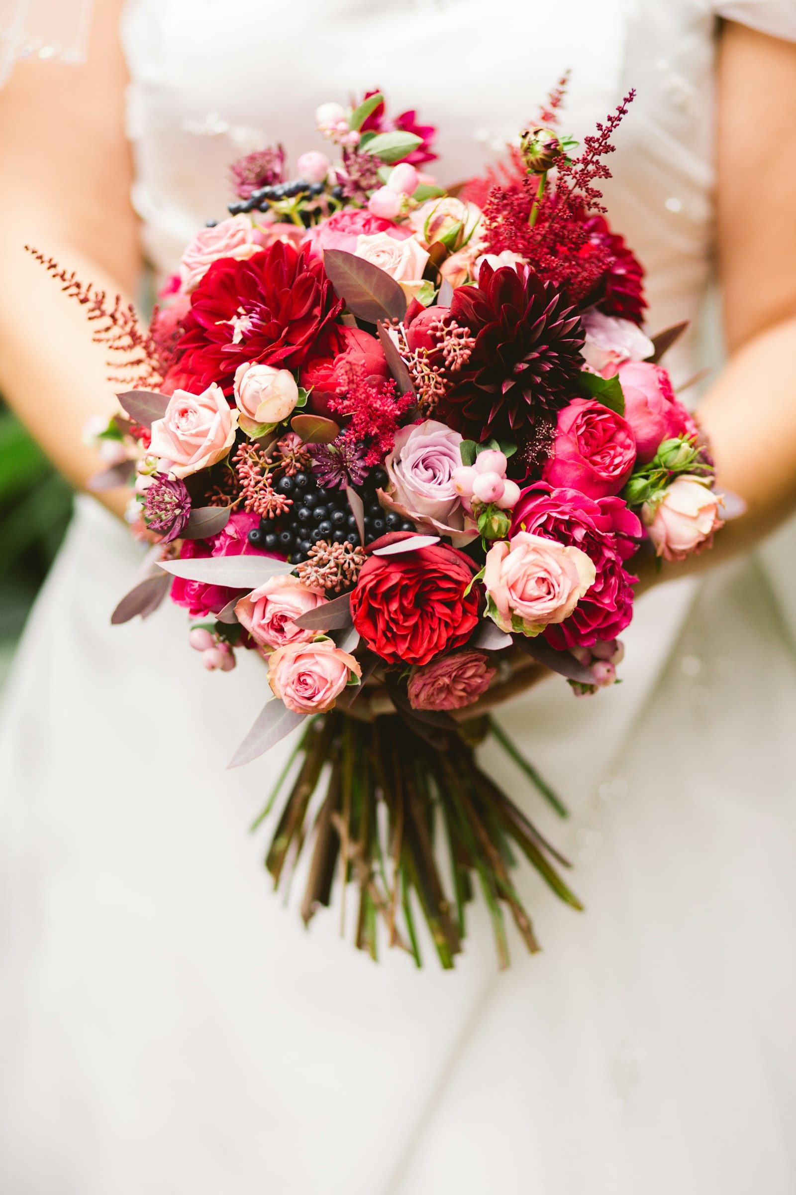 Ram de flors vermelles i rosades amb fulles verdes.